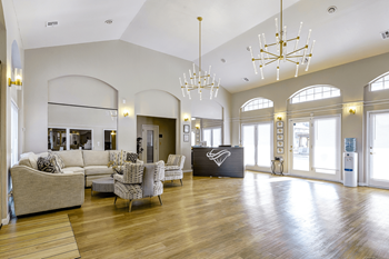 A large living room with couches and chairs and a reception desk